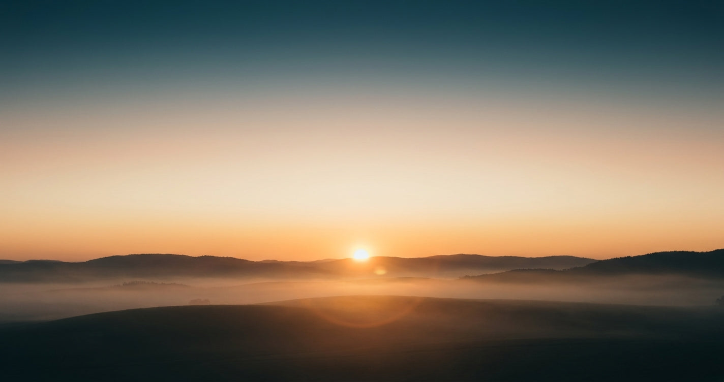 Amanecer con cielo dorado y niebla suave en el horizonte, metáfora de la primera hora del día para sostener la energía