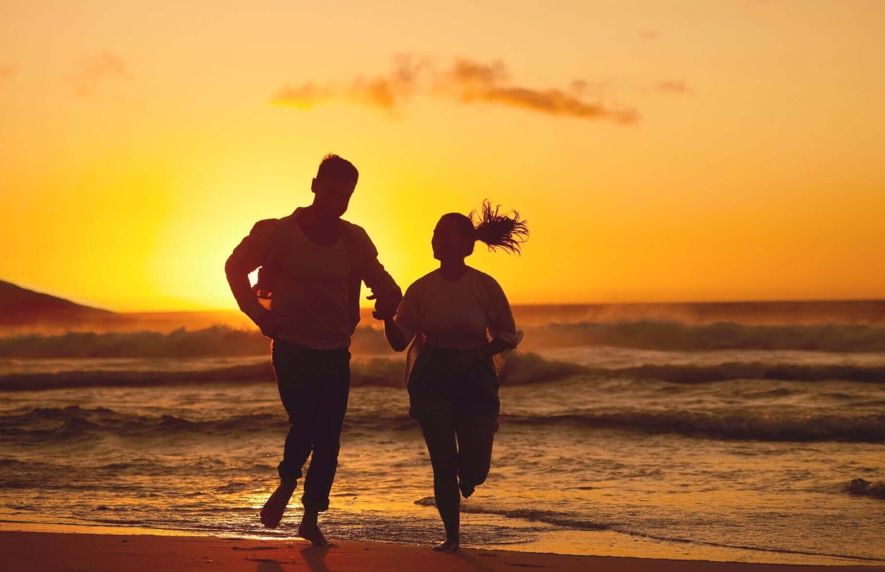 pleniage fitness beach and couple silhouette running at sunset