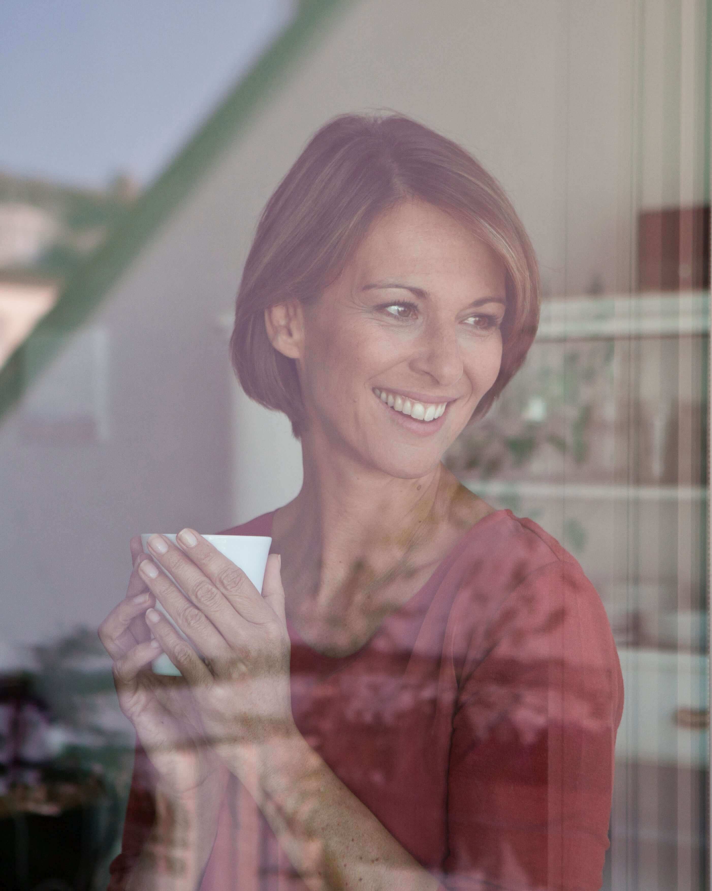 Pleniage Pro Calm ayuda a mantener el equilibrio emocional y la relajación. Mujer tomando una infusion y mirando por la ventana